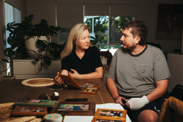 Helen and Drew Dowsley look at old family photos at home in Braemar, NSW.