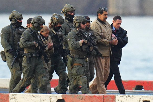 Nicolas Maduro and Cilia Flores surrounded by security en route to a federal courthouse in Manhattan on Tuesday (AEDT).