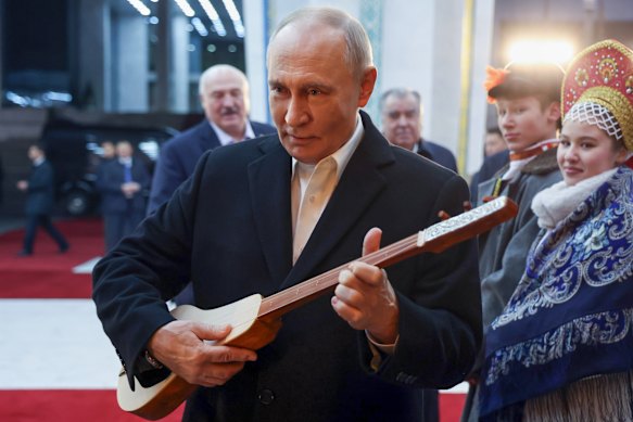 Putin holds a Kyrgyz instrument during a visit to Kyrgyzstan on Wednesday.