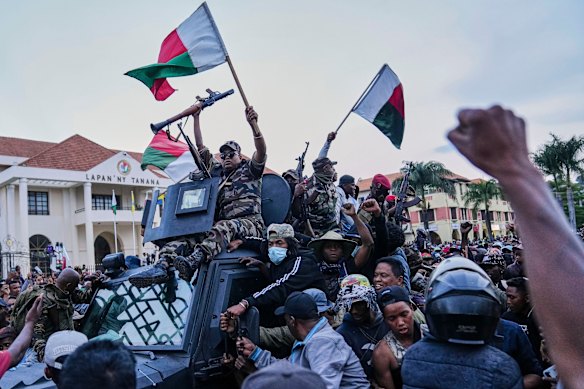 Soldiers are greeted by people gathering for a ceremony in tribute to demonstrators killed during recent anti-government protests in Antananarivo, Madagascar on Sunday.
