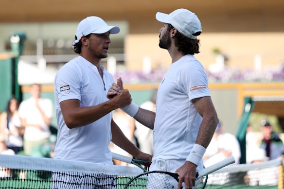 Luciano Darderi meets Jordan Thompson of Australia at the net following his defeat.