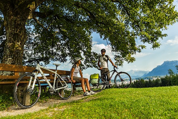 Cyclists pause for a well-earned rest along a shaded section of the Alpe Adria in Austria.