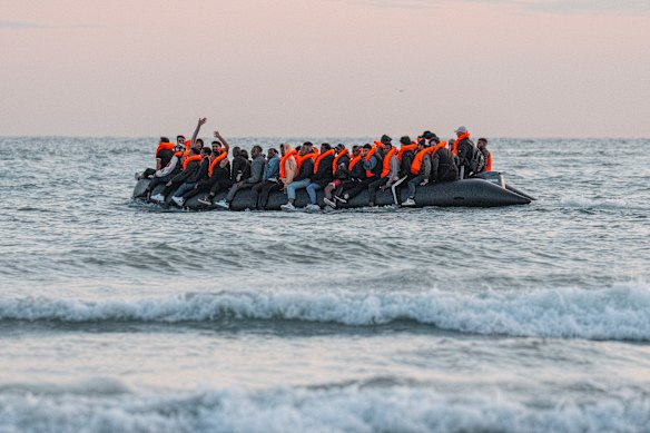 Migrants sit on a dinghy as it prepares to sail into the English Channel on July 10.