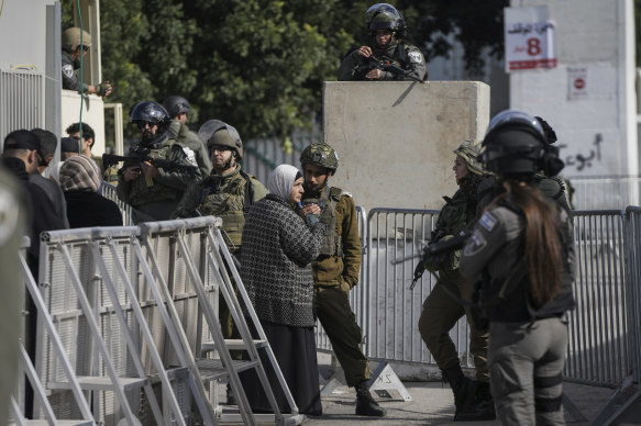 Palestinians go through a security check by Israeli soldiers as they cross from the West Bank city of Bethlehem to Jerusalem to participate in Friday prayers at the Al-Aqsa Mosque.