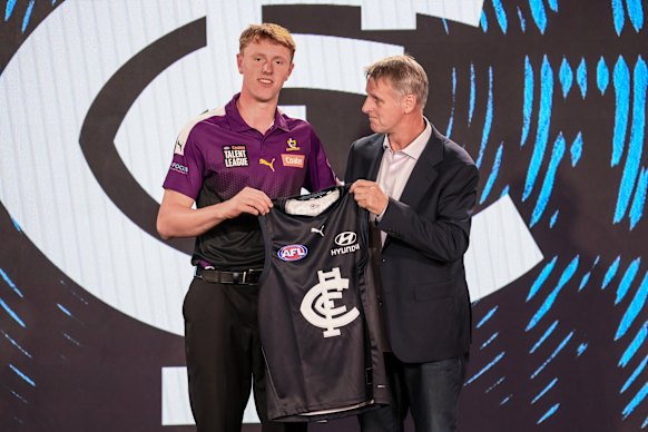 Harry Dean is presented his Carlton jumper by father Peter Dean.