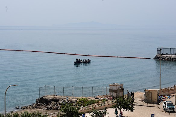 Civil Guard boats patrol alongside floating barriers off the coast of the Spanish enclave of Ceuta.