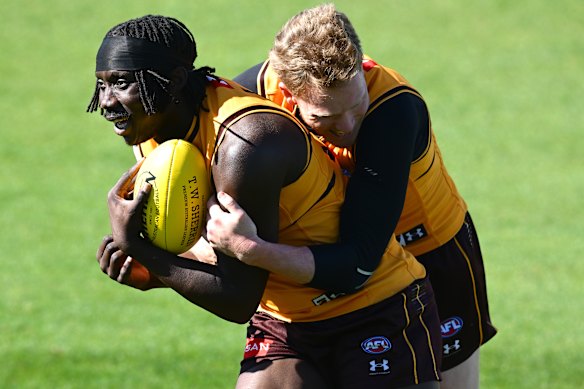 Sicily wraps up Mabior Chol in a tackle at training.