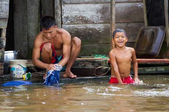 A father and son wash and play in the Itaya River, a tributary of the Amazon, at the “floating city” of Belen.