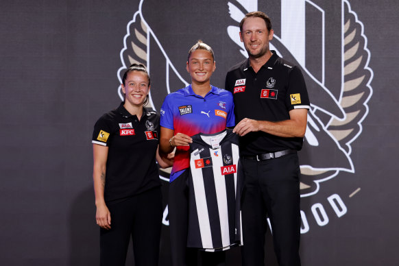 Ash Centra is welcomed to Collingwood by Brittany Bonnici (left) and Josh Fraser (right).