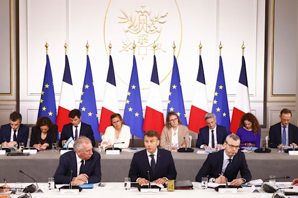 French President Emmanuel Macron, centre, his Prime Minister Francois Bayrou, left, and Presidency General Secretary Alexis Kohler meet with representatives of the sectors affected by the new Trump tariffs at the Elysee Palace in Paris. 