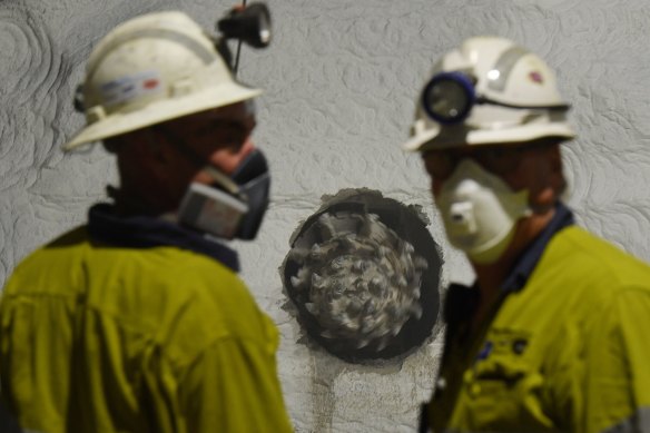 Staff watch as two roadheader tunnelling machines smash through sandstone during construction of WestConnex.
