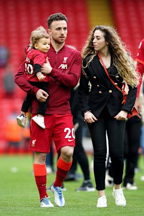 Liverpool’s Diogo Jota walks the pitch with his family after a Premier League match.