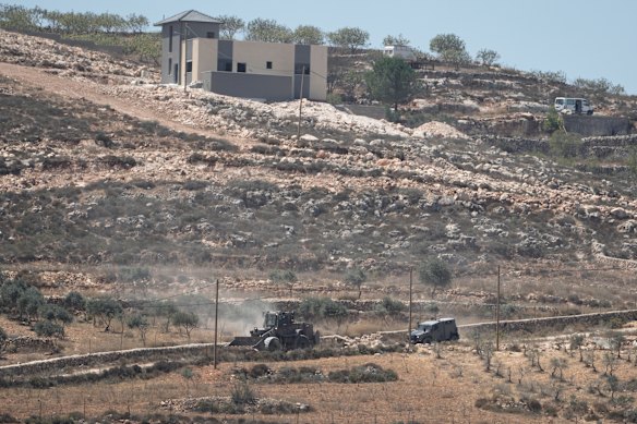 Israeli army vehicles operate near Palestinian houses in the West Bank, where Israeli settlers have this year ramped up a violent campaign against local Palestinians.