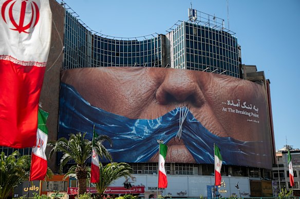 A poster in Tehran depicts Donald Trump with his mouth gagged by a blue ribbon in the shape of the Strait of Hormuz.