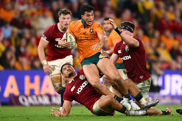 Joseph-Aukuso Suaalii of the Wallabies is brought down by a pack of Lions.