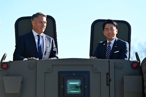 Defence Minister Richard Marles in a military vehicle with Japan’s Defence Minister Shinjiro Koizumi in Tokyo on Sunday.
