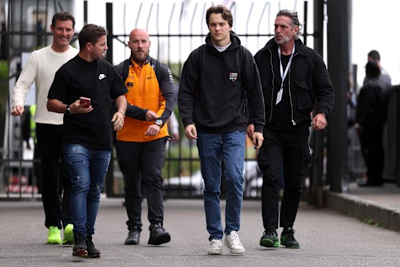 Oscar Piastri (second from right) arrives in the paddock at Sao Paulo with his manager Mark Webber (back left).