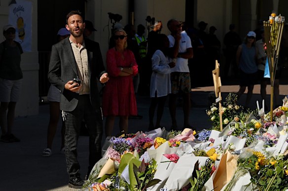 Rabbi Yossi Friedman (centre) leads people in prayers at the Bondi Pavilion at Bondi Beach in December.