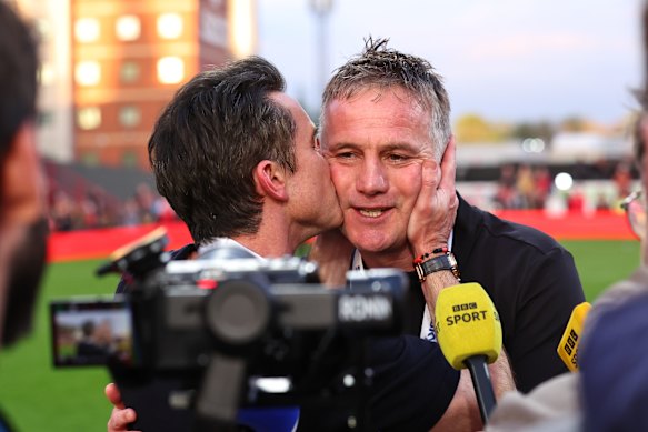 Coach Phil Parkinson is on the receiving end of an appreciative kiss from owner Rob Mac after Wrexham secured promotion to the Championship.