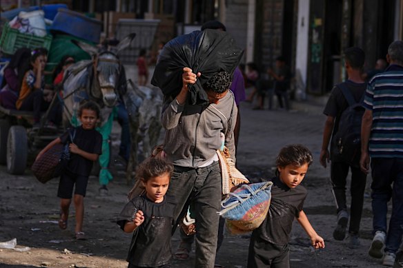 Children help carry possessions as residents flee Jabalia on Sunday.
