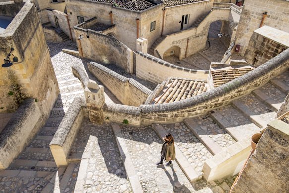 A pedestrian strolls through the undulating historic centre of Matera, southern Italy’s striking stone city.
