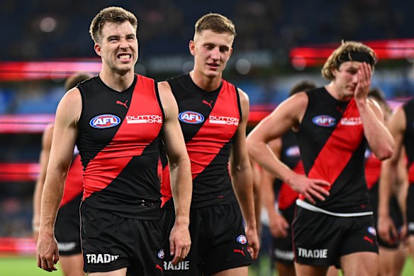 Zach Merrett and the Bombers leave the field after the loss against the Hawks.