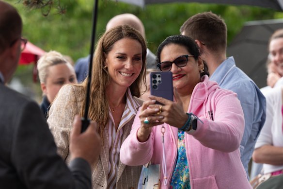 Despite heavy rain, the Princess of Wales stopped to take selfies and talk with staff and visitors.