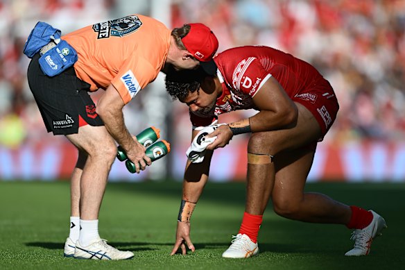 Tonga forward Eliesa Katoa receives treatment before leaving the field.