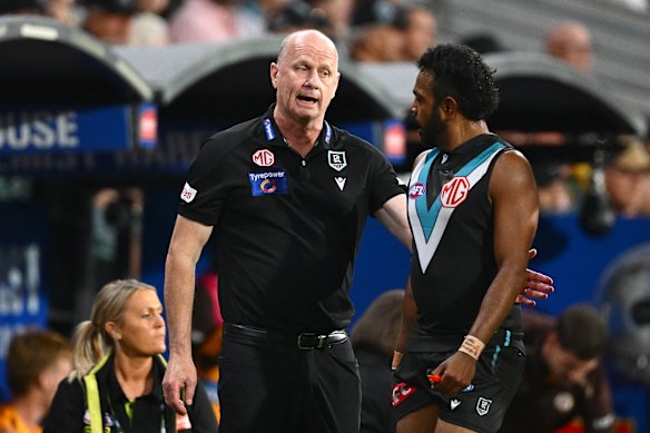Ken Hinkley speaks with Willie Rioli boundary-side during the Power’s at-times fiery clash with the Hawks in Gather Round.