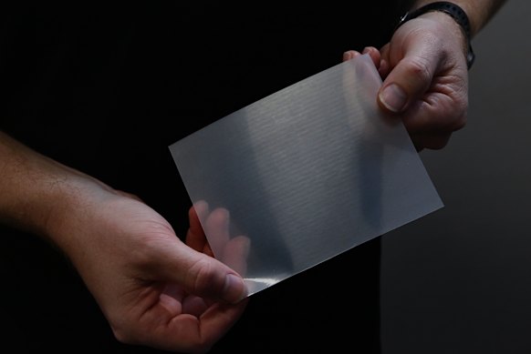 Scale, scale, scale: MicroTau partnerships manager Dylan Callender holds a sample of MicroTau’s sharkskin drag reducing material.