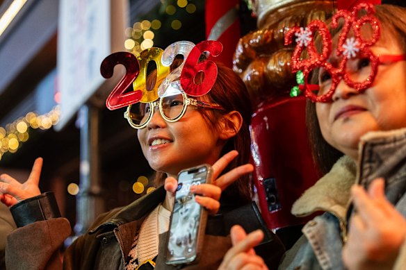 People pose for photographs at Lan Kwai Fong to celebrate the start of 2026 in the Central district of Hong Kong.