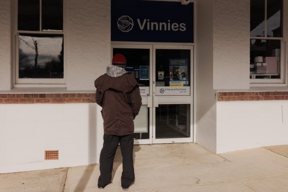 A man reads a sign notifying customers that Vinnie’s in Cooma is closed for the day in memory of Nowland.