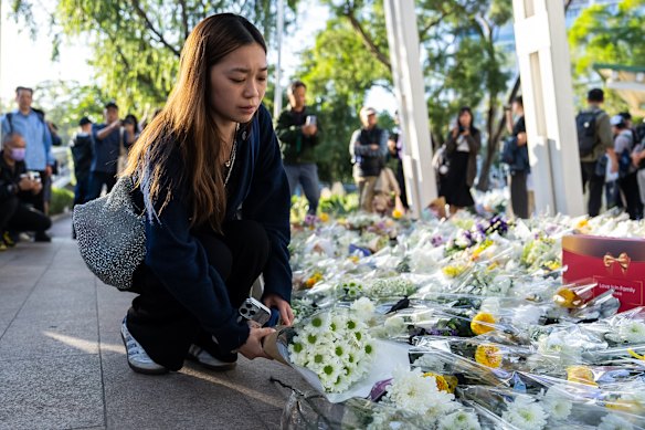 People place flowers near the site to mourn the victims of the deadly fire on Wednesday at Wang Fuk Court, a residential estate in the Tai Po district of Hong Kong’s New Territories