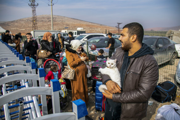 A Syrian holds his cat as he waits with others to cross into Syria from Turkey at the Cilvegozu border gate, near the town of Antakya, southern Turkey, on Tuesday.