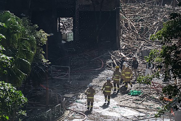 Hong Kong firefighters walk through the burned buildings at Wang Fuk Court on Saturday.