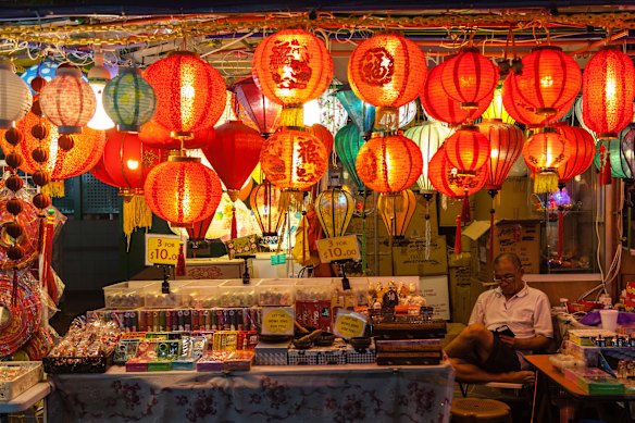 A street vendor in Chinatown watches over his store selling Chinese lanterns.
