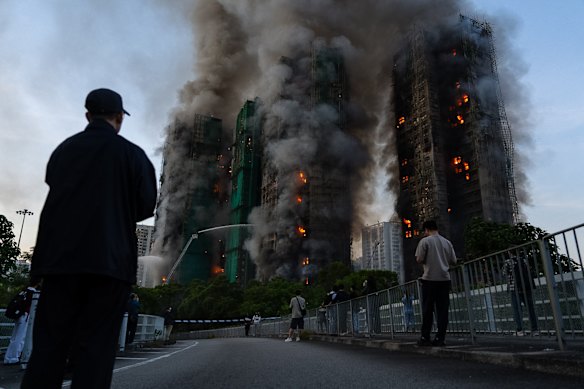 Onlookers watch as the Wang Fuk Court towers in Hong Kong’s Tai Po district burn.