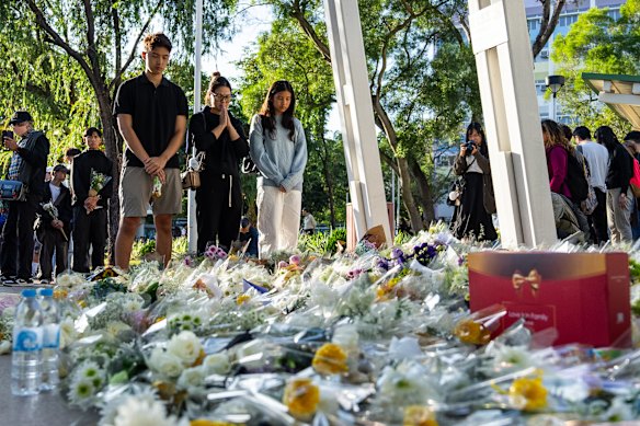 People pray and lay flowers to mourn the victims of the deadly fire.