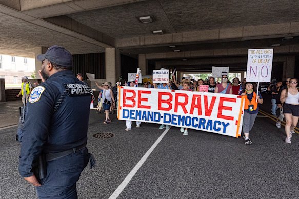 Activists with Free DC carry signs as they march to court on Friday.