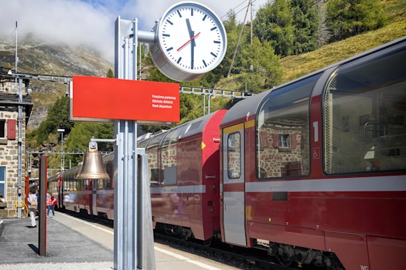  The Bernina Express pauses at the 2091 kilometres station at Alp Grum beside a ubiquitous Swiss station clock.