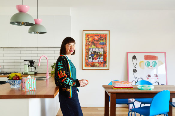 “The kitchen bench faces the backyard, a design feature we mimicked from the original house,” says Sarah Auld. “My uncle, Martin, made the dining table from spotted gum.” The “Arcade” pendant lights and “Fun” chairs are by Dowel Jones and the pink tapware is from Par Taps in Preston.