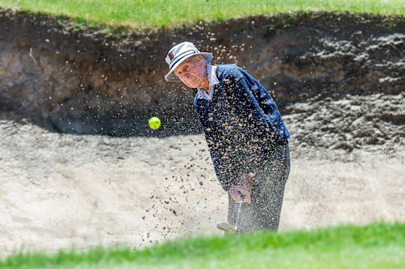  Bill Horn, 99, chips a ball out of a bunker at Portsea Golf Club.