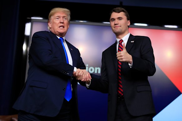 US President Donald Trump shakes hands with Charlie Kirk during a Generation Next White House forum in Washington in 2018.
