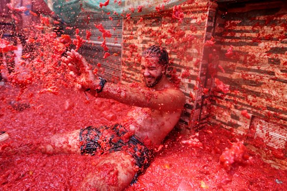 A reveler takes part in the annual “Tomatina” tomato fight fiesta, in the village of Bunol near Valencia, Spain.
