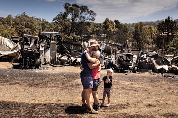 CFA volunteer Raewyn Rice greets her son after fighting fires all night and returning to her own home in Harcourt to find it was a twisted, blackened ruin.