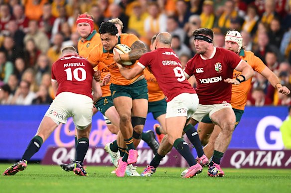 Len Ikitau tries to charge through the Lions defence.