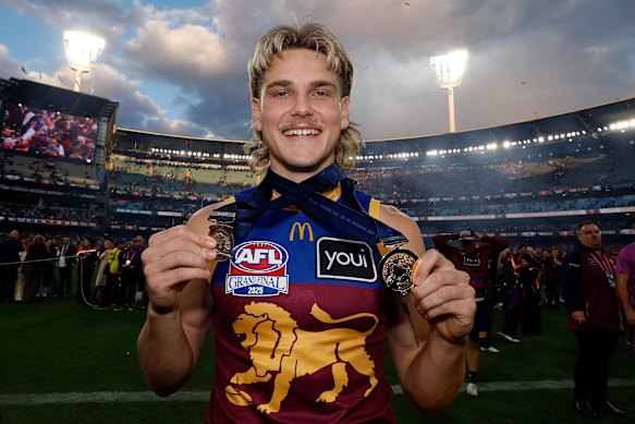Lion Will Ashcroft holds his Norm Smith Medal and his premiership medal after the 2025 flag win.