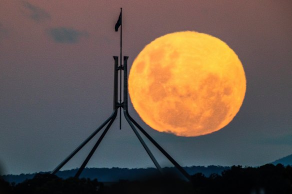 A supermoon rises over Canberra with Parliament House in the foreground, in May 2021.