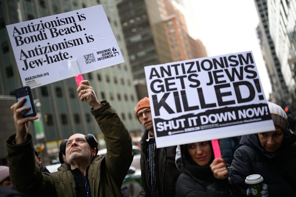People hold signs at a vigil outside the Australian Consulate in New York City in December.