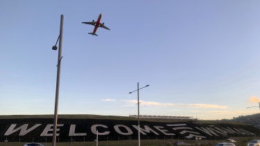 Un panneau géant peint près de la piste principale de l'aéroport international de Wellington accueille les voyageurs rentrant chez eux à Wellington, en Nouvelle-Zélande. 